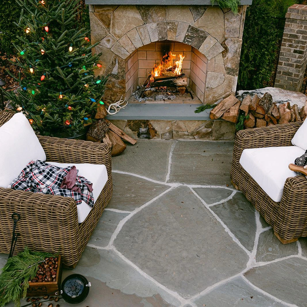 Rustic Christmas decorations around outdoor fireplace