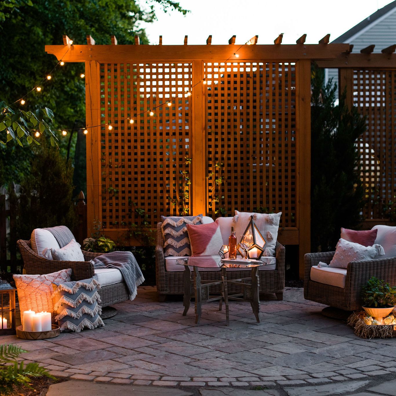 Paver patio with wood trellis privacy screens and string bistro lights