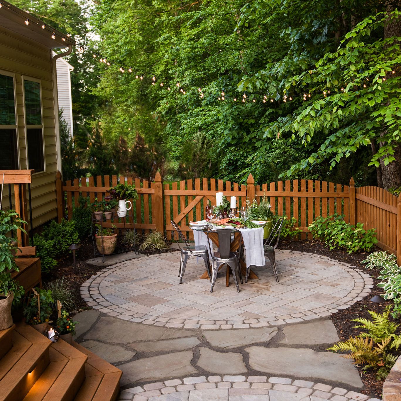 Paver patio with outdoor dining landscaping and string lights