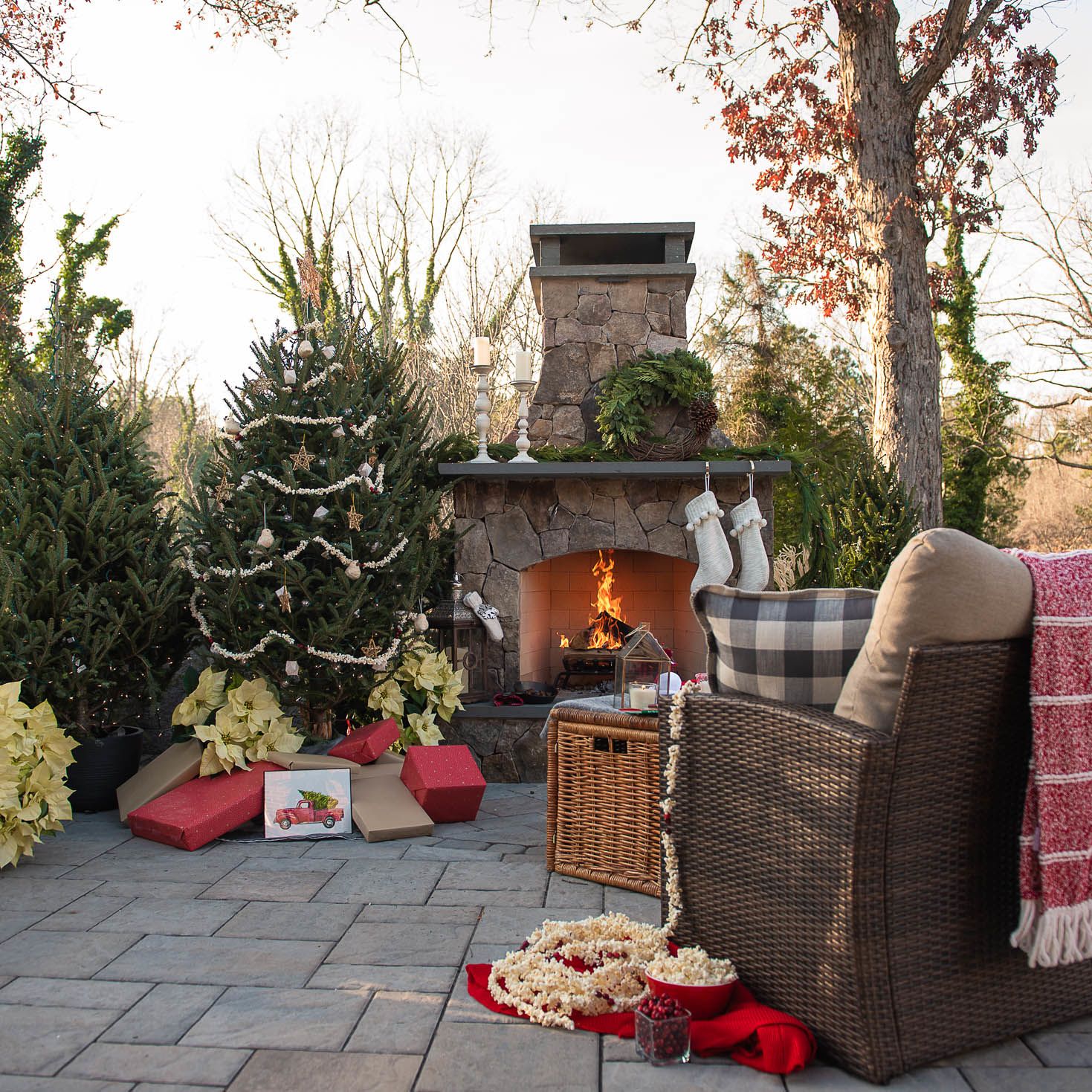 Outdoor fireplace decked with holiday greenery and lights