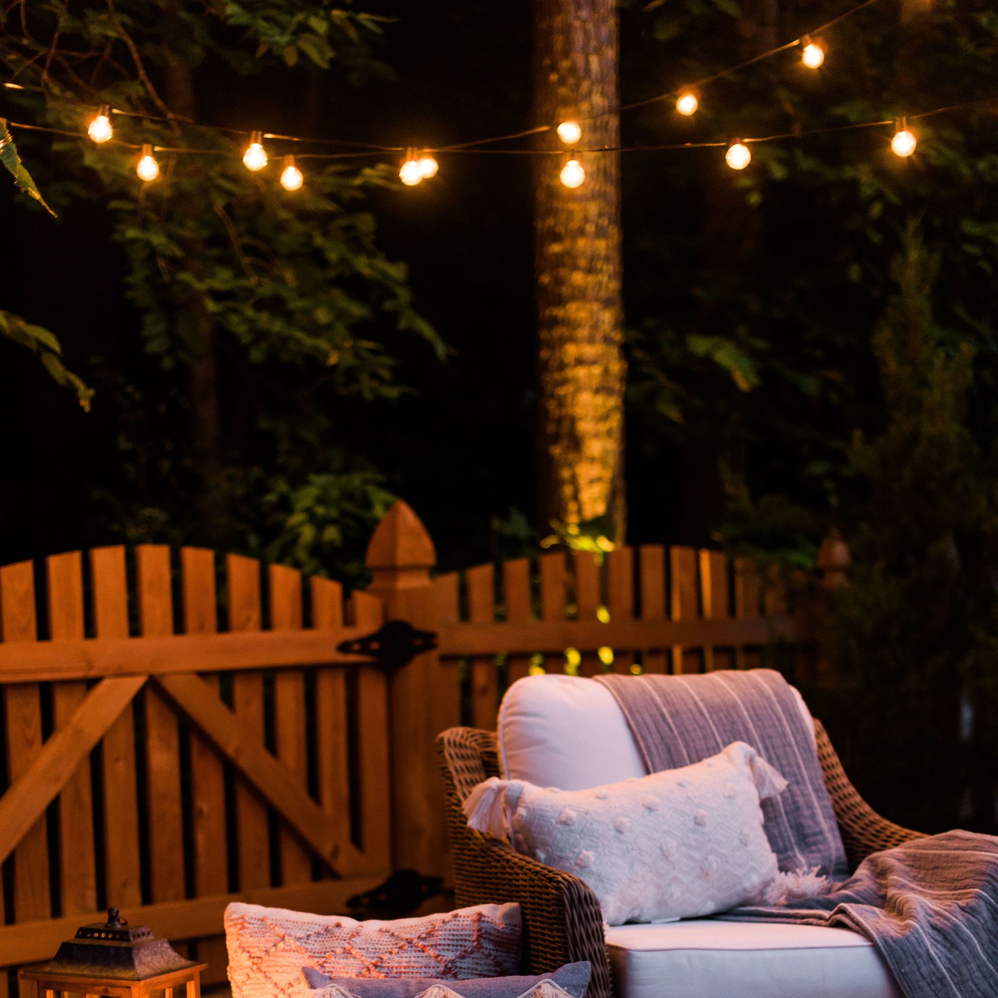 Paver patio with wood trellis privacy screens and string bistro lights