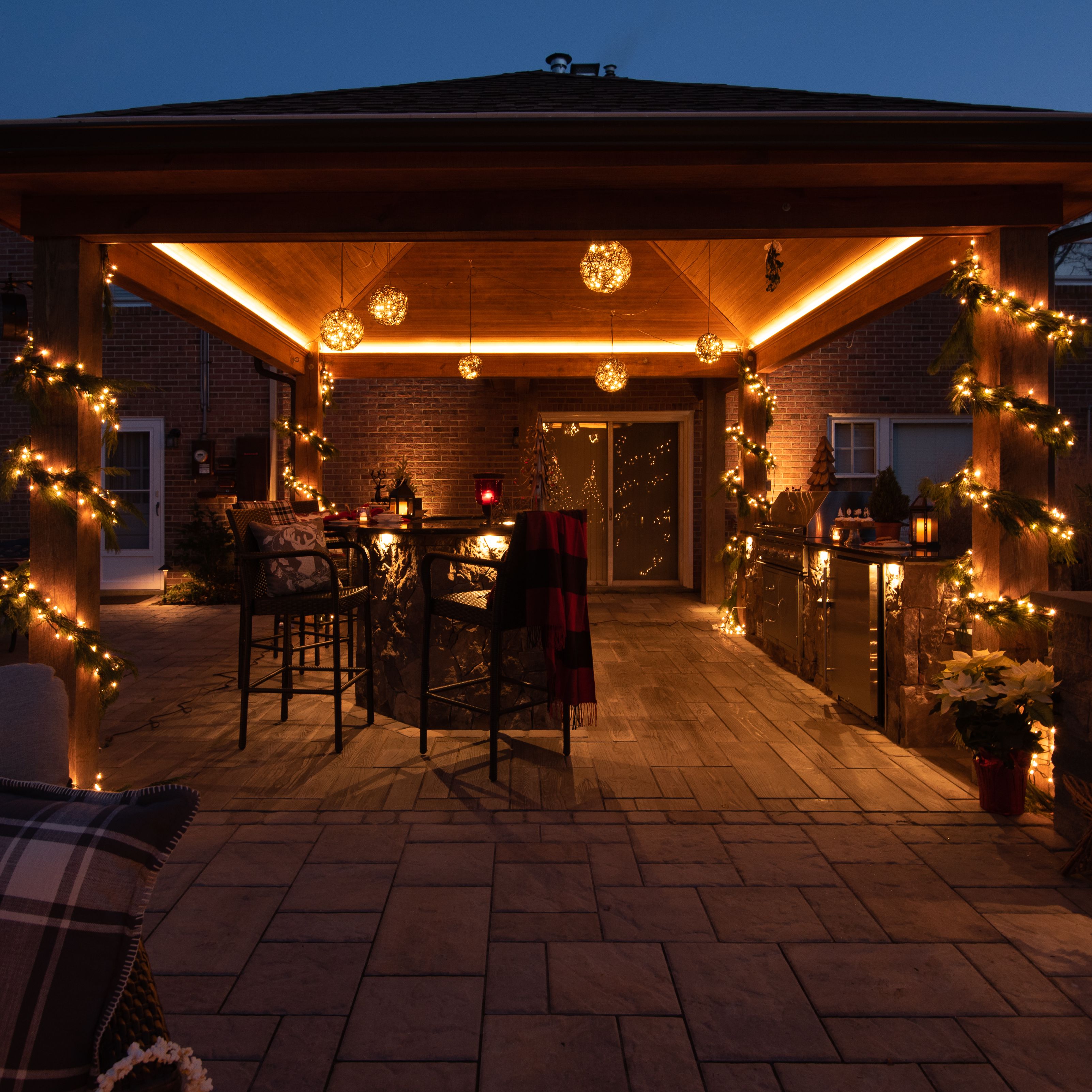 Outdoor living pavilion with fireplace lit and holiday charm